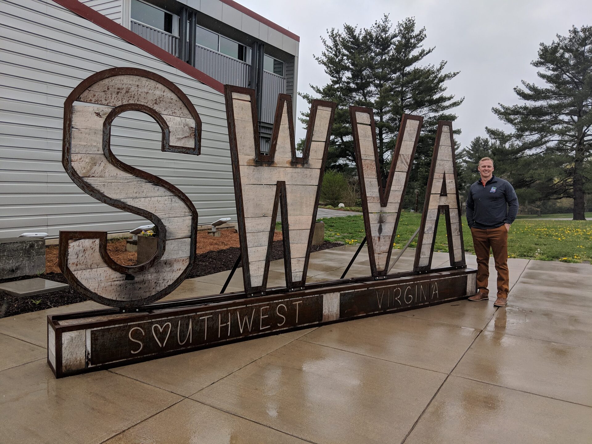Thomas A. Gibson standing beside a large wooden “SWVA” sign reading “Southwest Virginia”